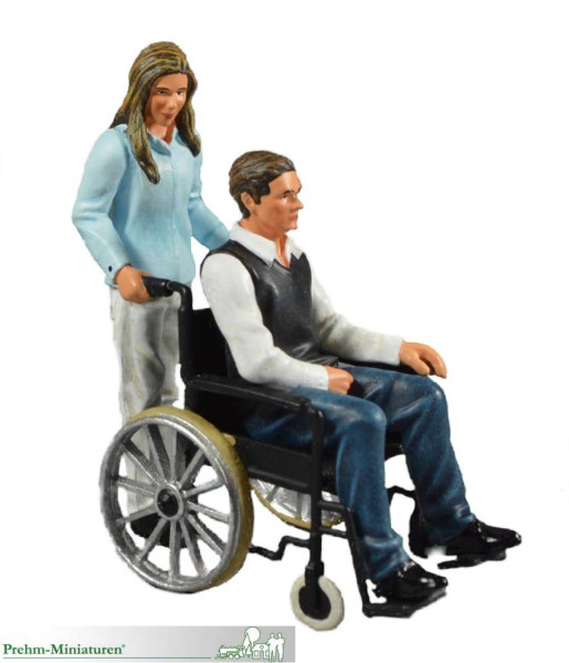 Mann im Rollstuhl mit Begleiterin, Metall